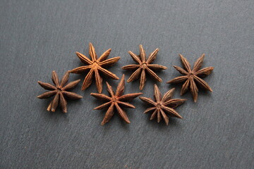 Star anise flowers and seeds  on grey stone background
