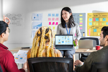Asian female creative designers present ux ui to team.Designers team working meeting in a modern office.