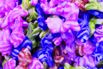 Colorful texture using as background. A lot of sweets. Background 3d rendering illustration. Orange and black multiple jelly candies in powdered sugar. Confectionery wallpaper concept. Copy space