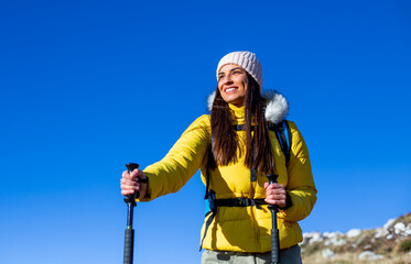 Fototapeta na wymiar Portrait of a smiling young female hiking in the mountain.