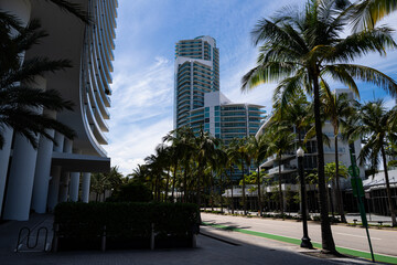 Fototapeta na wymiar Miami Beach, Florida, USA - May, 2020: Street in Miami with palms. Skyscraper at Miami Beach.