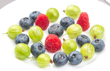 Fototapeta na wymiar Assorted fresh different berries on a white plate. useful vitamin healthy food fruit. healthy vegetable breakfast