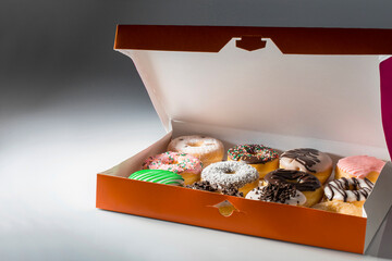 orange box of donnuts on neutral background