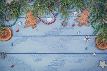Christmas or New Year flat lay: pine branches and some decorations for the Christmas tree on the blue boards