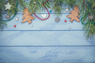 Christmas or New Year flat lay: pine branches with some decorations and necklaces on the blue boards