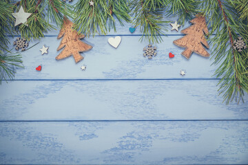Christmas or New Year flat lay: pine branches with some decorations on the blue boards