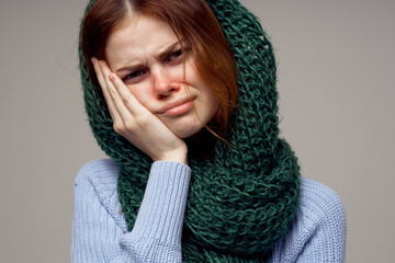 woman knitted scarf on her head health problems runny nose blue sweater