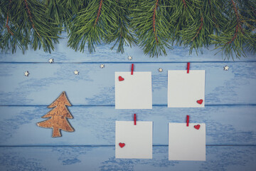 Christmas or New Year mock up: pine branches, white stickers with red clothespins and wooden Christmas tree on the blue boards