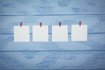 Mock up: four white stickers with red clothespins on the blue boards