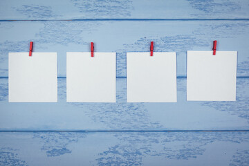 Mock up: four paper stickers with red clothespins on the blue boards