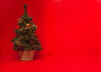 small decorated christmas tree in a red background