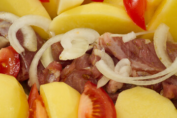 pork meat, potatoes, tomatoes and onions, ready to bake