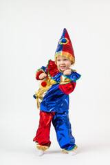 Child kid boy preschooler in Harlequin, Arlecchino, Arlequin, costume dancing. Vertical shot isolate on white background. Concept of theater and kindergartens.