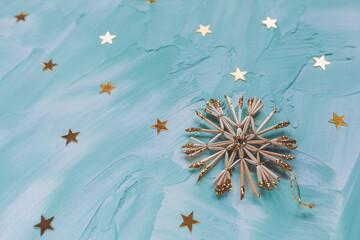 Christmas diy decoration snowflakes and gold stars confetti on cyan backround. Winter holidays concept. Flat lay, copy space, top view, social media hero header template