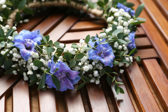 Beautiful flower wreath on wooden background, closeup