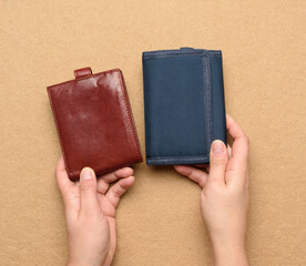 female hand holds leather and blue textile wallet
