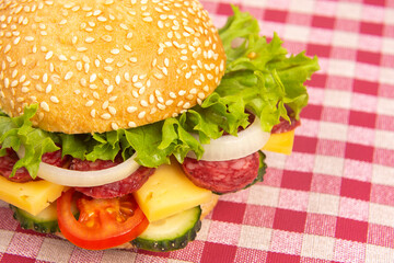 Hamburger with vegetables and sausage. Fast food and breakfast. Calories and diet.