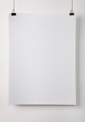 White blank poster hanging near light wall