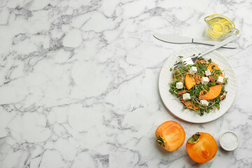 Delicious persimmon salad served on white marble table, flat lay. Space for text