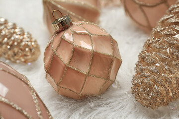 Collection of beautiful Christmas tree baubles on white faux fur, closeup