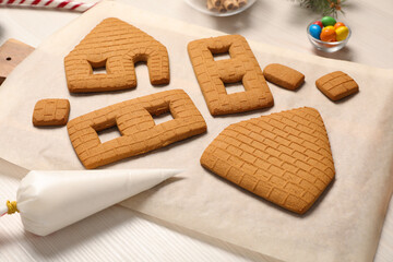 Parts of gingerbread house on white table