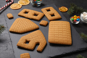 Parts of gingerbread house on black table, closeup