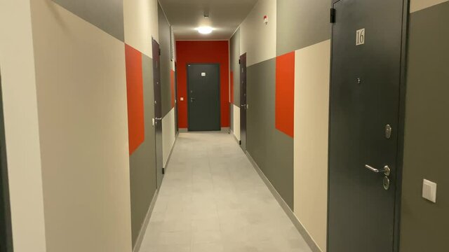 Walking in apartment building empty corridor with doors. High quality 4k footage
