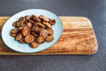 plant-based food, vegan sausage cut into salami slices and pan fried with cracked pepper on top