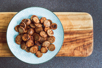 Fototapeta premium plant-based food, vegan sausage cut into salami slices and pan fried with cracked pepper on top