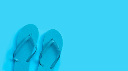 Blue flip flops on blue background.