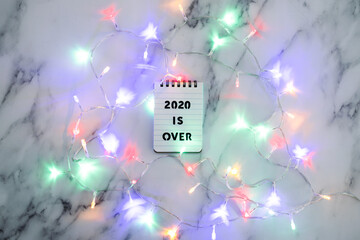 festive fairy lights with text 2020 is over, facing the challenges caused by the outbreak of the covid-19 virus