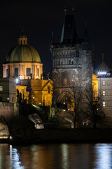 Obraz premium .Charles Bridge and lights from street lights are reflected on the surface of the Vltava River in the center of Prague at night in the Czech Republic
