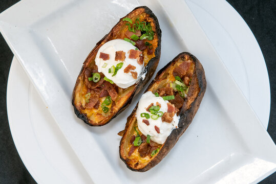 Overhead View Of Delicious Appetizer Dish Of Baked Potato Skins With Sour Cream, Cheese, And Chives  Makes The Mouth Water And The Stomach Growl.