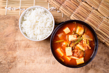 Korean food, Kimchi soup with fofu and cooked rice on wooden background