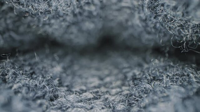 Macro shot of woolen fabric. Slider dolly extreme close-up of clothing material blue fabric texture. Woollens, woolens, wool fibers. Warm winter clothing. Shot with laowa 24mm probe lens