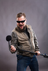 Fototapeta na wymiar Bearded emotional rock singer with microphone studio portrait.