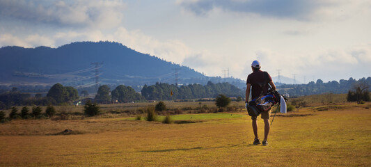 golfer walking to the other hole on a golf course