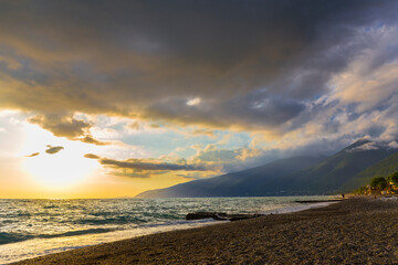 Beautiful shoreline scene with waves at sunset beams