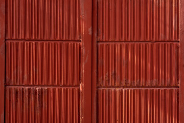 Red orange door wth pink wall of old and shabby house in rural Bulgaria