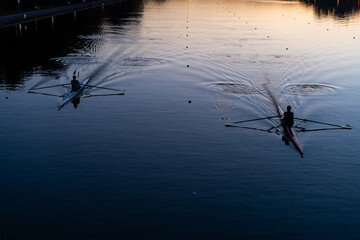 Kayaks racing in canal water reservoir for rowing sport practice on sunset vibrant background in Plovdiv, Bulgaria