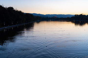 Fototapeta premium Vibrant blue and pink sunset over rowing canal with water reflections of trees in Plovdiv, Bulgaria