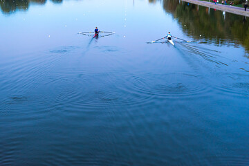 Kayaks racing in canal water reservoir for rowing sport practice on sunset vibrant background in...