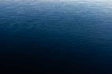 Fototapeta na wymiar Deep blue water ripple texture vibrant monochrome river sea canal