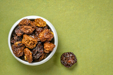 goldenberry - white ceramic bowl on green handmade paper, copy space