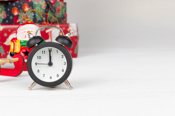 gift boxes, snowman and alarm clock on wooden white background with gold veins