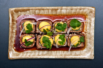 comida japonesa plato de Gyu asupara maki con tocino 