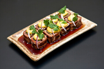 comida japonesa plato de Gyu asupara maki con tocino 