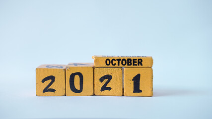 Wooden block calendar with a focus on October 2021. White background