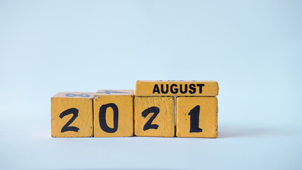 Wooden block calendar with a focus on August 2021. White background