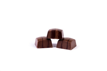 Three light and dark striped chocolates stacked in a pyramid isolated over white